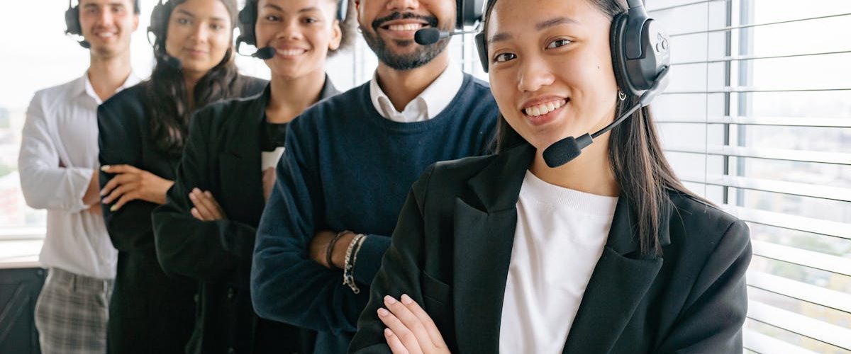 pexels-photo-8867482-8867482 A diverse group of smiling call center agents in an office setting.
